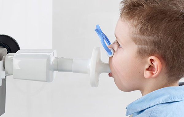 Garçon lors d'un examen en pneumologie avec un accent sur les tests de fonction pulmonaire